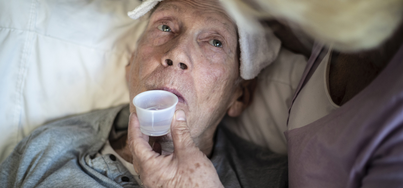image of an elderly man taking medicine